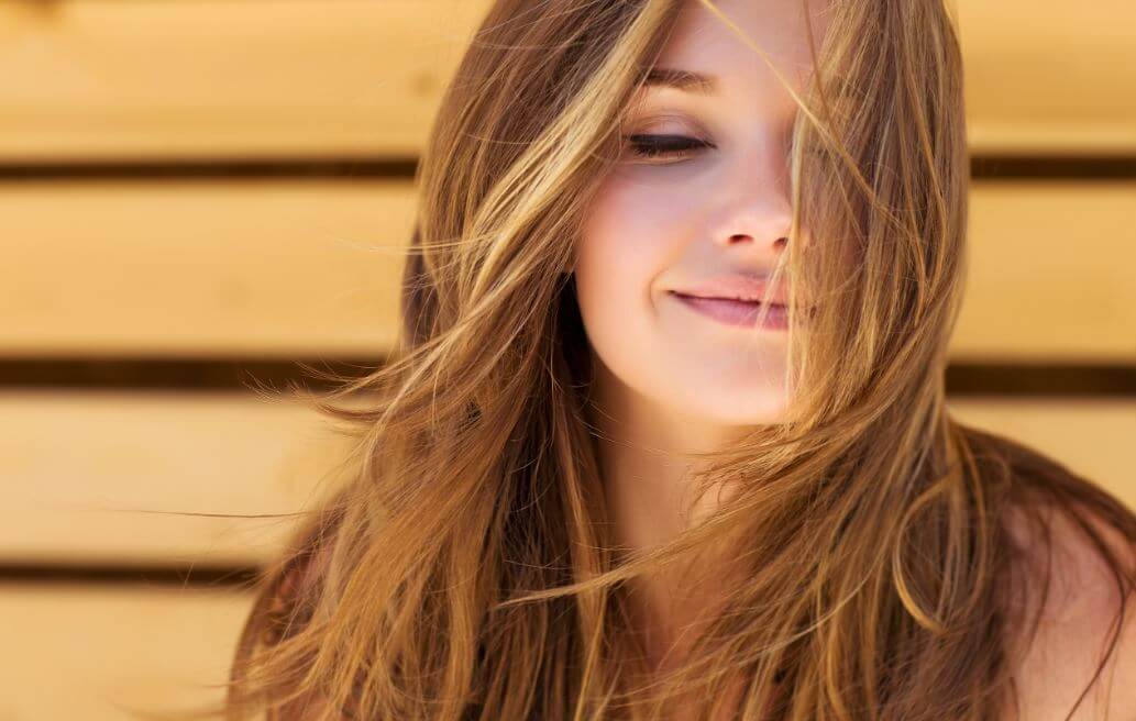 Girl with long hair smiling.