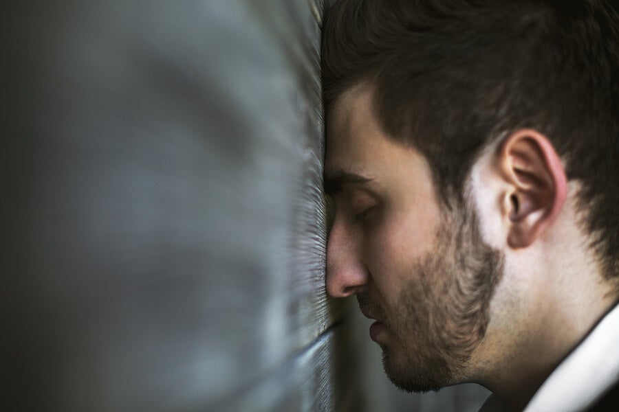 Man with his face leaning against the wall