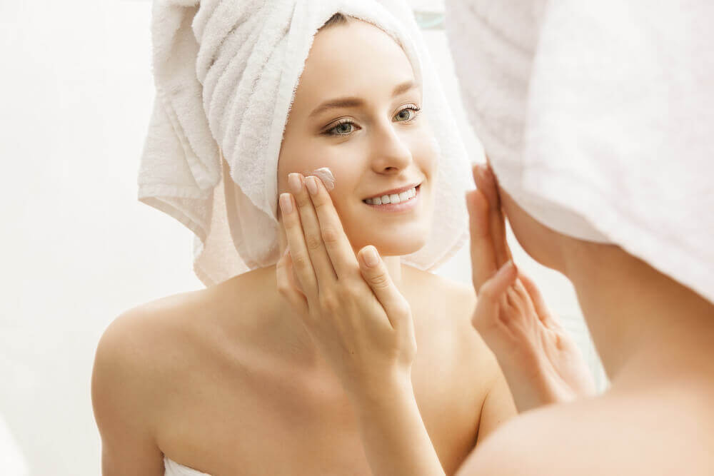 woman applying cream on her face