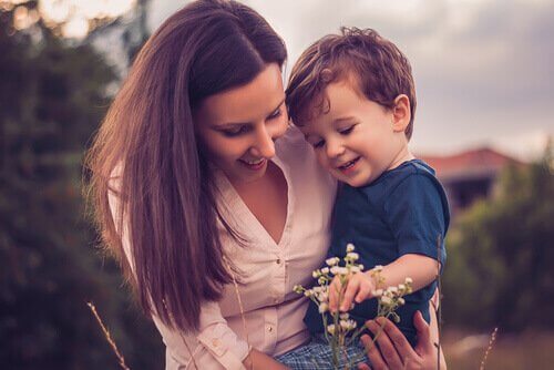 Mother-holding-her-child-in-arms-while-seeing-a-flower