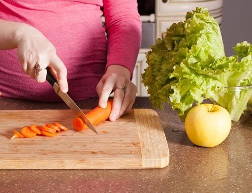 Pregnant woman cutting carrot