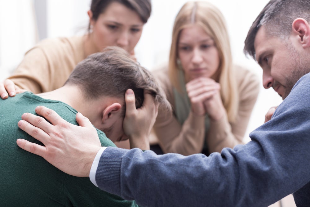 man-receiving-support-from-his-friends