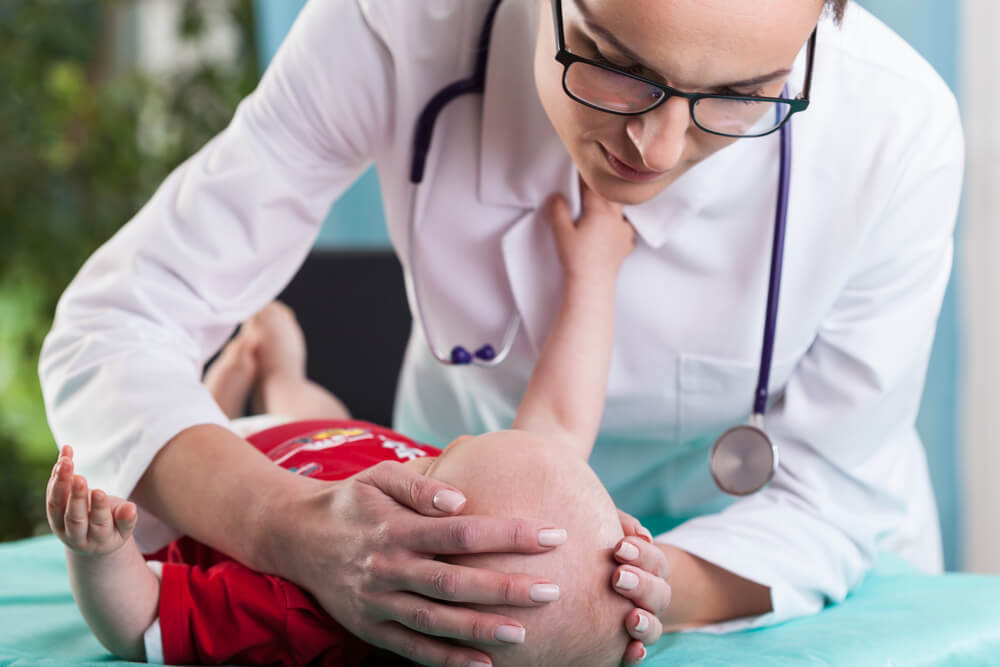 Doctor examining the head of the baby who has hit his head.