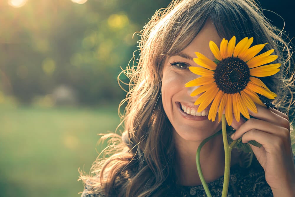 woman-with-sunflower-flower-covering-one-eye